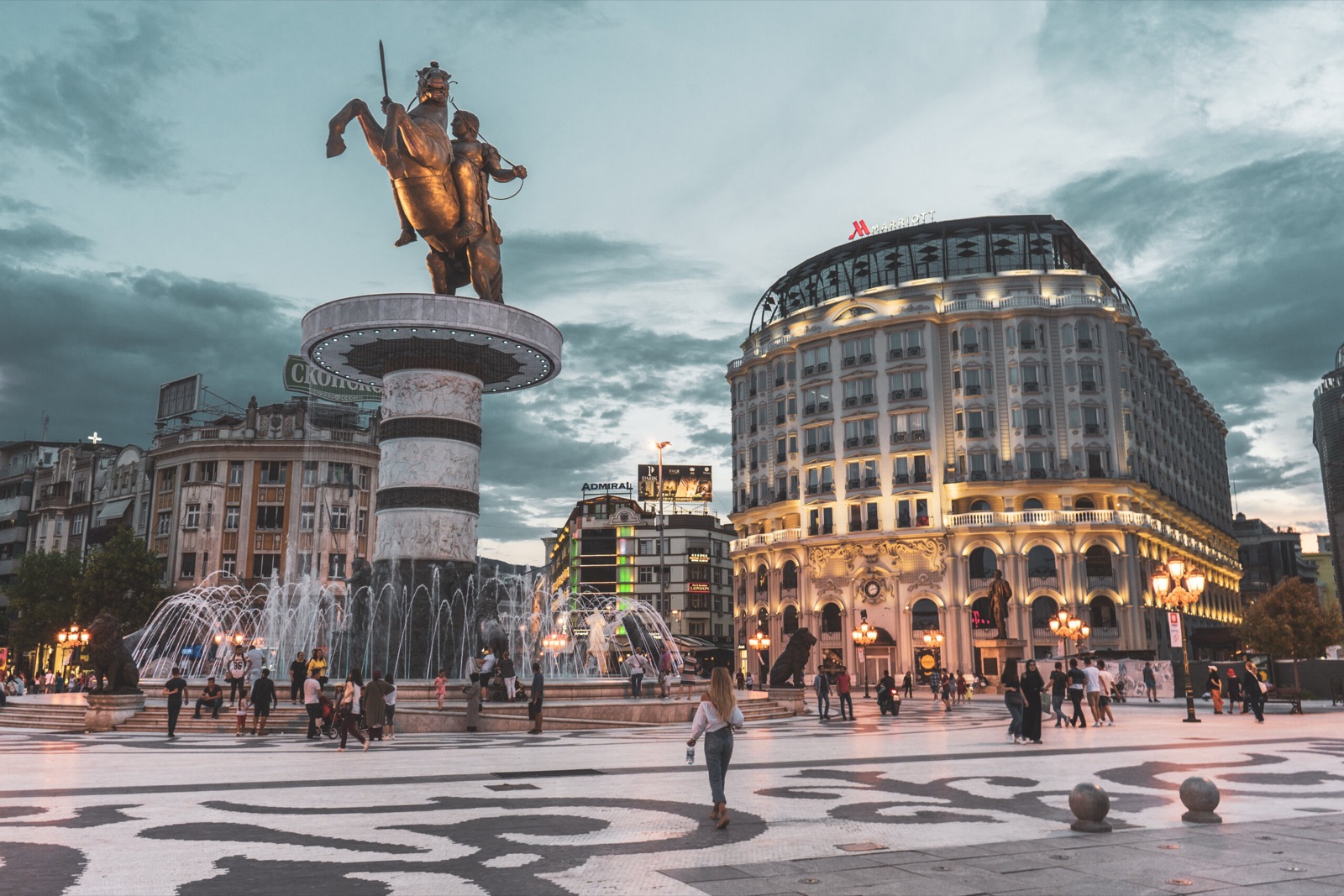 Macedonia Square in Skopje at dusk, with the fountain, the statue and an evening crowd