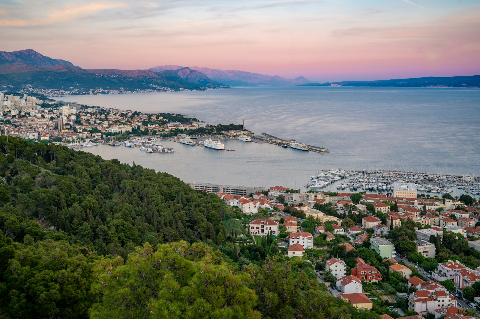 Split and its harbour seen from Marjan hill at dusk, with the coast and mountains beyond